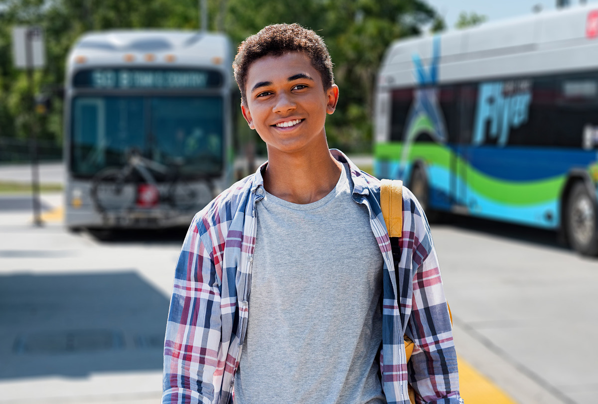 Student in front of buses.