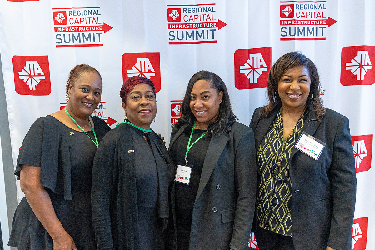 Members from the RCIS event posing in front of a backdrop